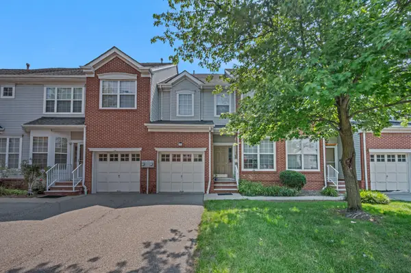 Front exterior with brick facade, attached garage and mature trees