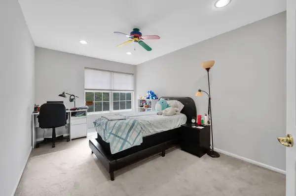 Second bedroom with desk and carpeting