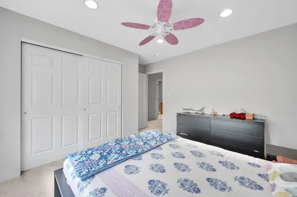 Bedroom with dresser and closet doors