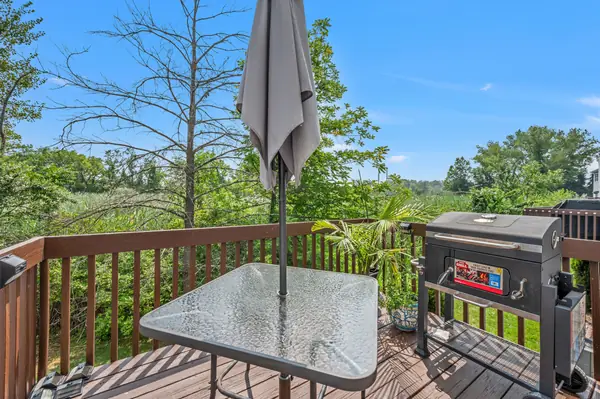 Deck with patio table, grill and open tree-lined views